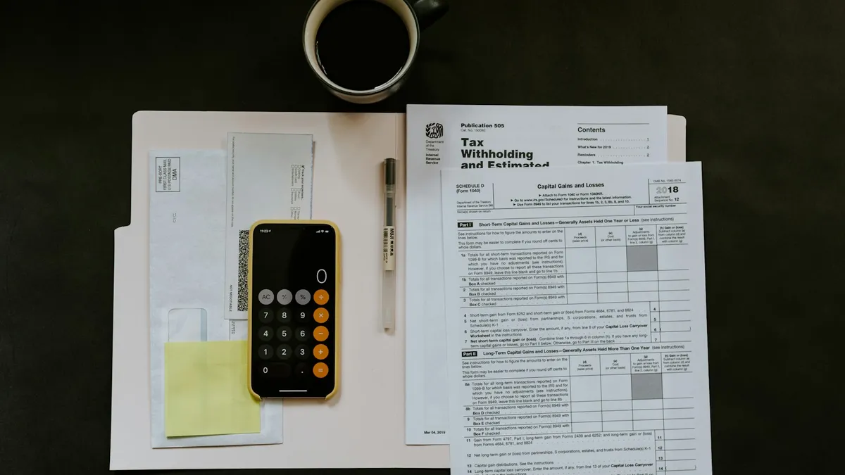 Calculatrice posée sur des relevés bancaires pour calculer un taux d'endettement