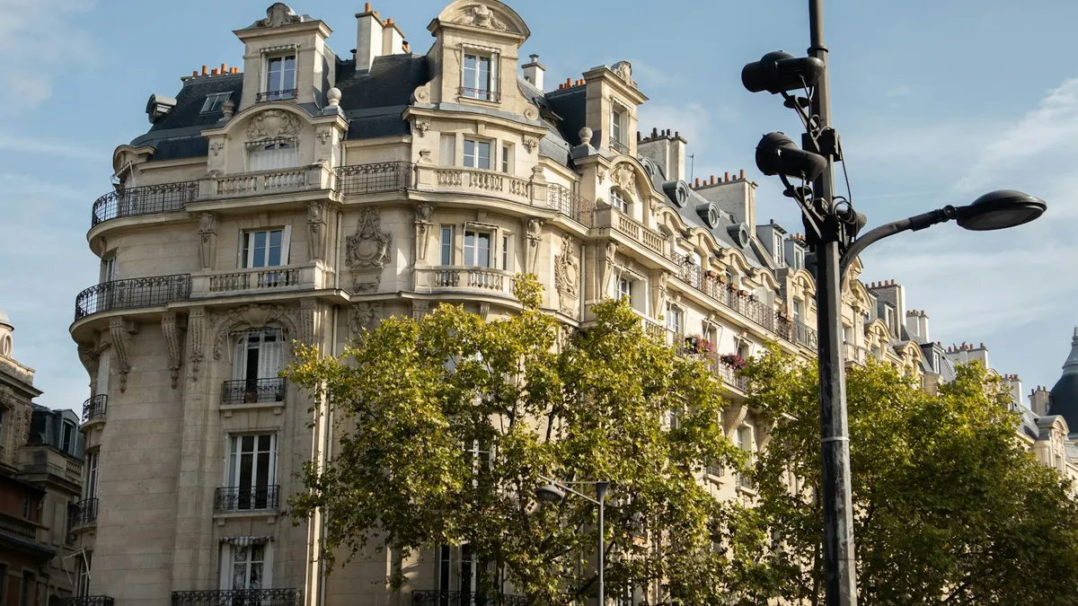 Immeuble haussmannien parisien avec balcons en fer forgé, typique de l'investissement locatif dans l'ancien