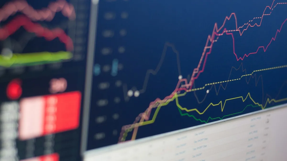 Poste de trading avec plusieurs écrans de cotations et de graphiques boursiers